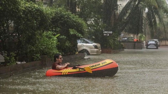 A man rows an inflatable raft inside a waterlogged building society in Mumbai, India, July 4, 2026. REUTERS/Francis Mascarenhas