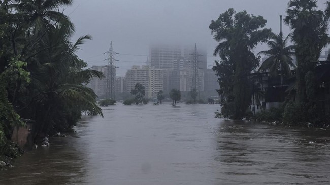 Buildings are shrouded in monsoon clouds near a waterlogged road following heavy rainfall in Vasai, India, July 7, 2026. REUTERS/Francis Mascarenhas