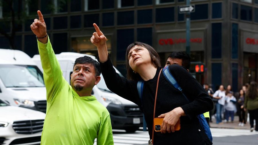 Orang-orang menunjuk ke atas di dekat sebuah gedung di Jalan ke-42, nan dilaporkan mempunyai masalah struktural, di Kota New York, AS, 7 Juli 2026.