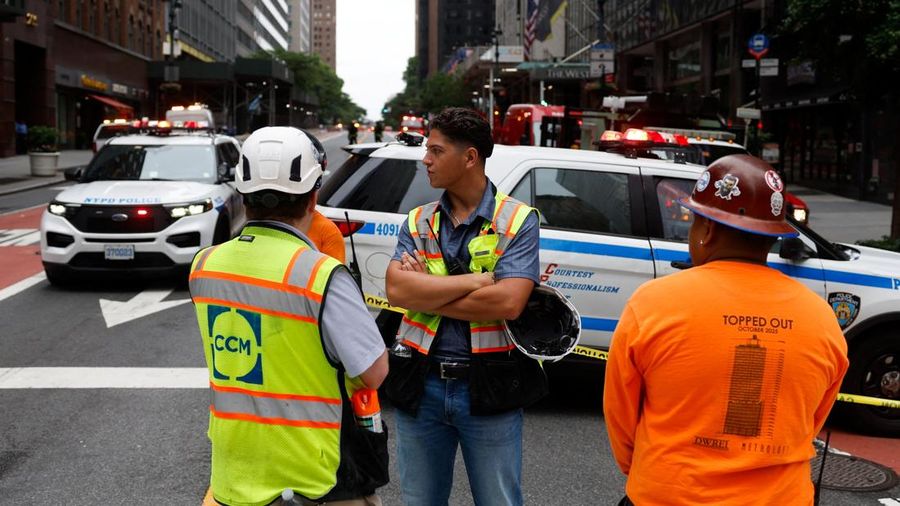 Para pekerja berdiri di dekat sebuah gedung di Jalan ke-42, nan dilaporkan mempunyai masalah struktural, di Kota New York, AS, 7 Juli 2026.