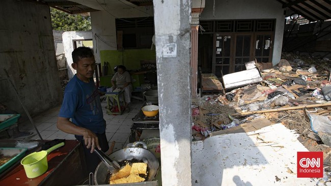 Warga melintas di samping bangunan yang telah dibongkar secara mandiri karena terdampak proyek pembangunan jalan baru di kawasan Pasar Minggu, Jakarta, Rabu (8/7/2026).