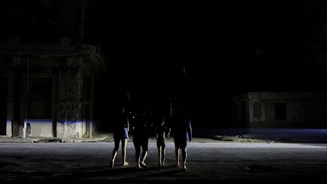 People cross a street as Cuba's national electric grid collapsed at midday, leaving around 10 million people without power, in Havana, Cuba,  July 6, 2026. REUTERS/Norlys Perez