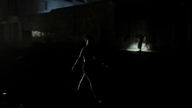 A woman walks on a street as Cuba's national electric grid collapsed at midday, leaving around 10 million people without power, in Havana, Cuba July 6, 2026. REUTERS/Norlys Perez