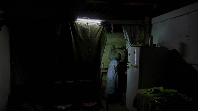 Cook Yolanda Liquijons, 88, prepares milk for her daughter's breakfast in the makeshift kitchen of her shelter, after power was restored in parts of the capital city, as Cuba struggles to restore power after the collapse of its national grid the day