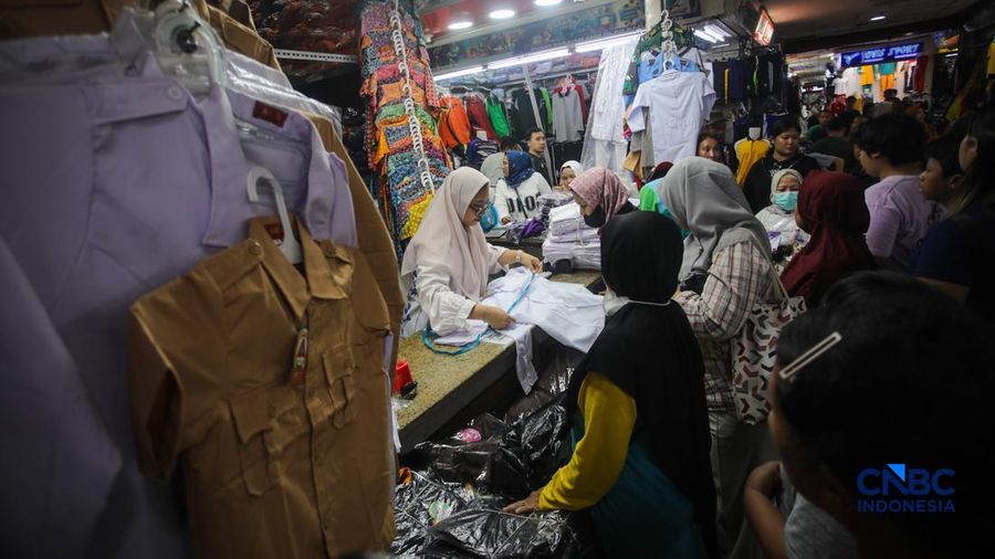 Orang tua mencocokkan seragam sekolah ke anaknya pada toko penyedia seragam sekolah di Pasar Tanah Abang, Jakarta, Kamis (9/7/2026).