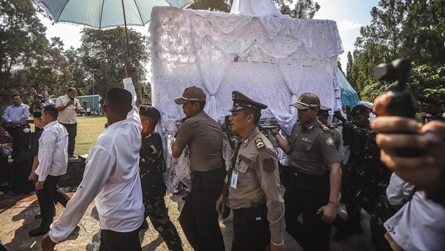 Petugas mengusung keranda jenazah anggota DPR Rachmat Gobel sebelum upacara pemakaman di TMP Kalibata, Jakarta, Jumat (10/7/2026).