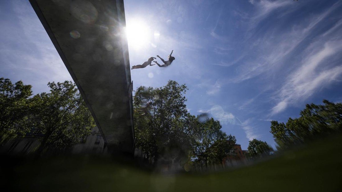 Teenagers jump into the Canal Saint Martin in central Paris, on July 5, 2026. (Photo by Olivier MORIN / AFP)