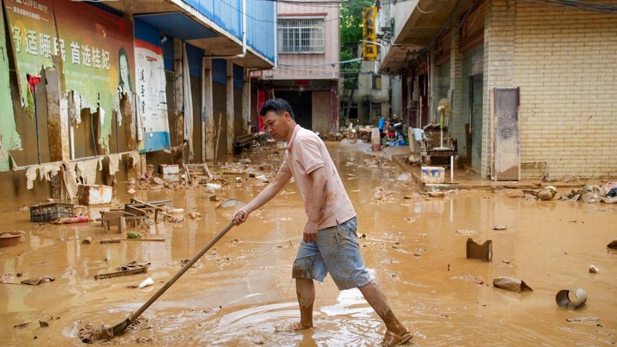 Seorang laki-laki membersihkan lumpur setelah hujan lebat nan dibawa oleh topan Maysak di kota Sanli nan terendam banjir di Guigang, Daerah Otonomi Guangxi Zhuang, Tiongkok, 9 Juli 2026.