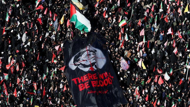 Mourners carry a banner against U.S. President Donald Trump as they gather on the day of the burial of Iran's late Supreme Leader Ayatollah Ali Khamenei, who was killed on February 28 in Israeli and U.S. airstrikes, in a culmination of a mass funera