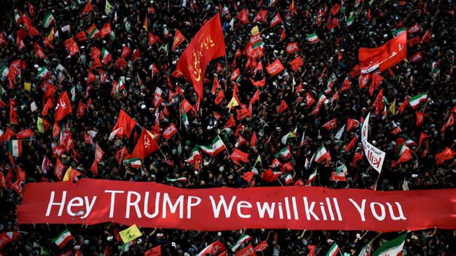 Mourners carry a banner against U.S. President Donald Trump as they gather on the day of the burial of Iran's late Supreme Leader Ayatollah Ali Khamenei, who was killed on February 28 in Israeli and U.S. airstrikes, in Mashhad, Iran, July 9, 2026. RE