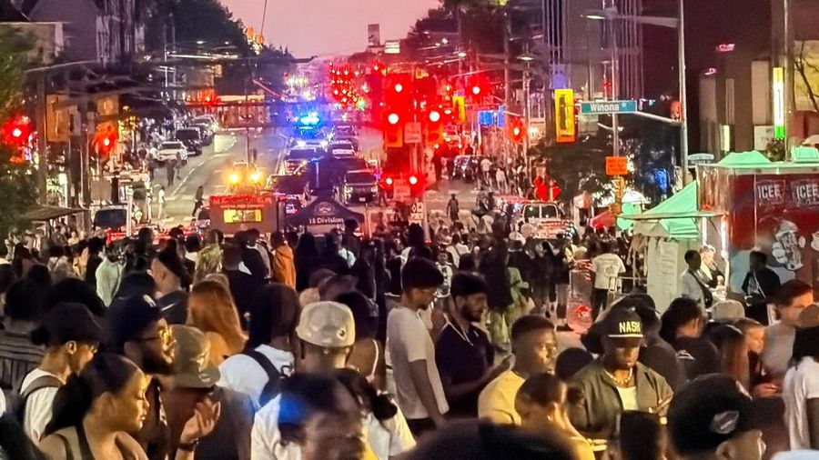 Orang-orang berkumpul saat petugas darurat memberikan pertolongan di letak kejadian setelah penembakan mematikan, di sebuah pagelaran jalanan bertema salsa di Toronto, Ontario, Kanada, 11 Juli 2026. (REUTERS/Cole Burston)