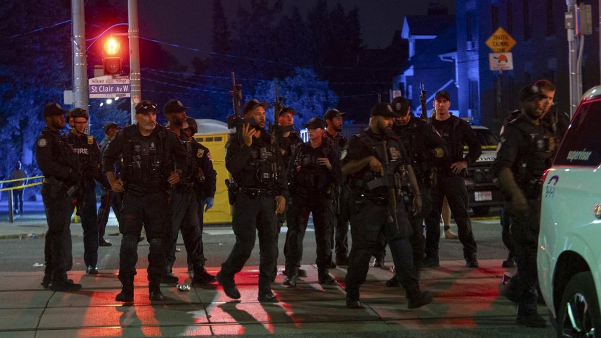 Police officers and other law enforcement personnel are seen at the intersection of St. Clair West and Arlington Avenue, near the site of a shooting that occurred at the Salsa on St. Clair Festival in Toronto on the evening of July 11, 2026. Police i