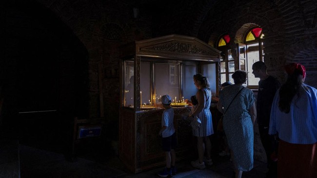 People light candles at the Monastery of the Great Meteoron at Meteora, near Kalambaka, Greece, July 12, 2026. REUTERS/Louiza Vradi