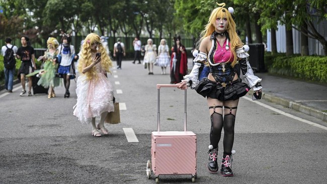 Cosplayers walk as they arrive outside the venue of the Bilibili World 2026 in Shanghai on July 12, 2026. (Photo by Hector RETAMAL / AFP)