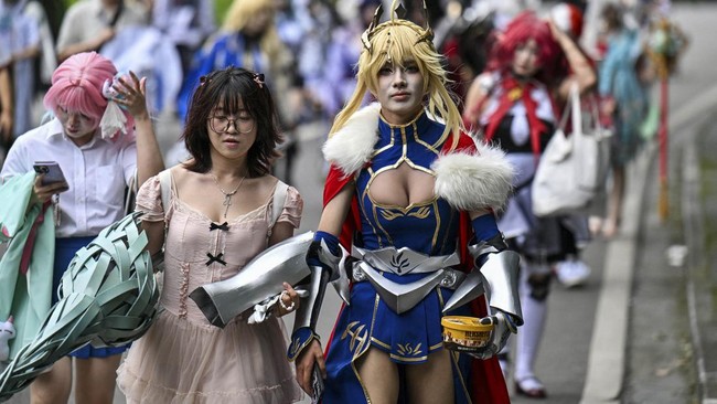 Cosplayers walk as they arrive outside the venue of the Bilibili World 2026 in Shanghai on July 12, 2026. (Photo by Hector RETAMAL / AFP)