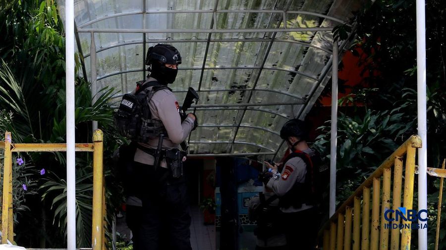 Petugas kepolisian bersenjata berjaga di dalam SDN Srengseng Sawah 15, Jakarta, Senin, (13/7/2026).  Sebuah teror ancaman bom terjadi di hari pertama masa pengenalan lingkungan sekolah (MPLS). (CNBC Indonesia/Muhammad Sabki)