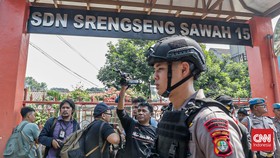 Sejumlah petugas keamanan berjaga di area peneroran bom di SDN Srengseng Sawah 15, Jakarta, Senin (13/7). (CNN Indonesia/Febria Adha L)