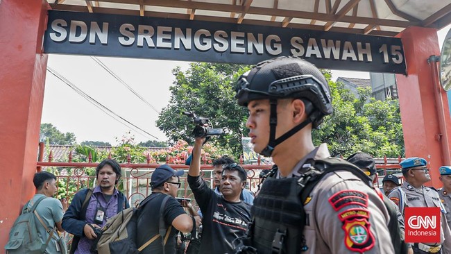 Sejumlah petugas keamanan berjaga di area peneroran bom di SDN Srengseng Sawah 15, Jakarta, Senin (13/7). (CNN Indonesia/Febria Adha L)