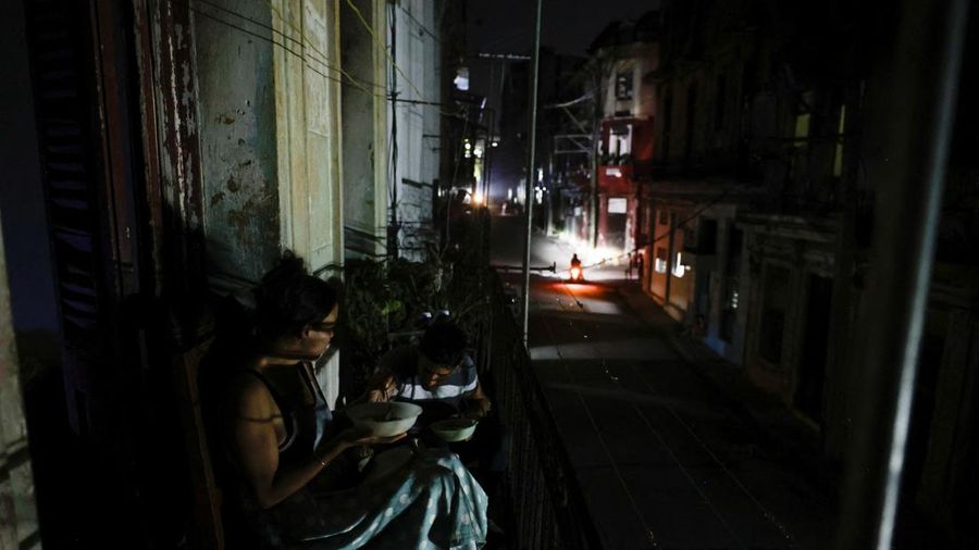 Warga sebuah gedung apartemen, nan dikenal di Kuba sebagai "solar," makan malam di anjungan saat jaringan listrik nasional Kuba runtuh, menandai pemadaman total kedua dalam seminggu di tengah krisis daya parah nan telah menjadikan pemadaman listrik