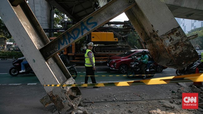 Kondisi jembatan penyeberangan orang di Jalan Kapten Tendean, Jakarta, nyaris roboh setelah tertabrak truk bermuatan alat berat, Selasa (14/7). Salah satu tiang penyangga JPO bergeser sekitar tiga meter akibat benturan tersebut. (CNN Indonesia/Adi Ib
