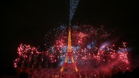 Fireworks light up around the Eiffel Tower during a choreographed firework and drone show to celebrate Bastille Day, in Paris, on July 13, 2026, on the eve of the annual Bastille Day Parade in the French capital. (Photo by LOU BENOIST / AFP)