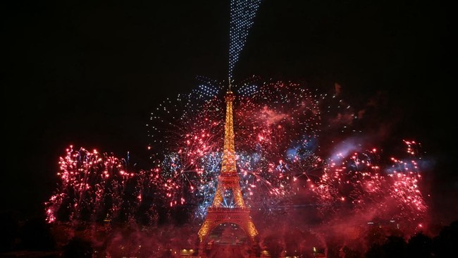 Fireworks light up around the Eiffel Tower during a choreographed firework and drone show to celebrate Bastille Day, in Paris, on July 13, 2026, on the eve of the annual Bastille Day Parade in the French capital. (Photo by LOU BENOIST / AFP)