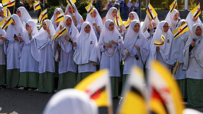 Students displayed Brunei flags during a ceremonial guard of honour parade marking the 80th birthday of the world's longest-reigning living monarch, Brunei's Sultan Hassanal Bolkiah, at Taman Haji Sir Muda Omar 'Ali Saifuddien in Bandar Seri Begawan,