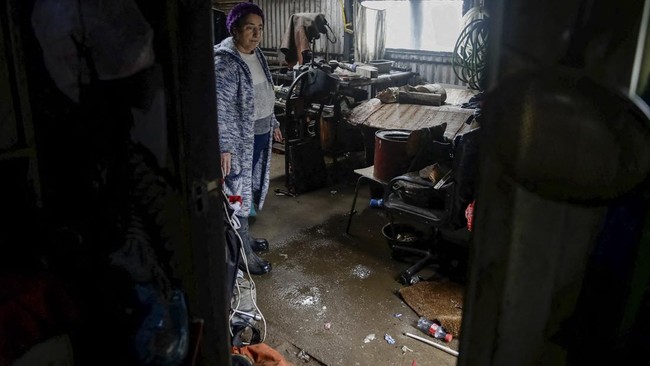 Flor Bazan stands by floodwater in her property, after heavy rain fall during a weather front caused flooding, and led the Chilean authorities to declare a preventive state of emergency at the start of the week, in Arauco, Chile, July 16, 2026. REUTE