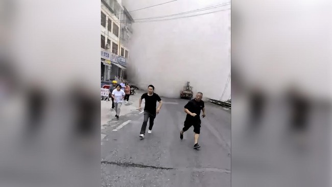 People run away from a cloud of dust rising as buildings collapse due to a landslide in Chongqing, China, July 17, 2026, in this screengrab obtained from a social media video. Social Media/via REUTERS  THIS IMAGE HAS BEEN SUPPLIED BY A THIRD PARTY. N