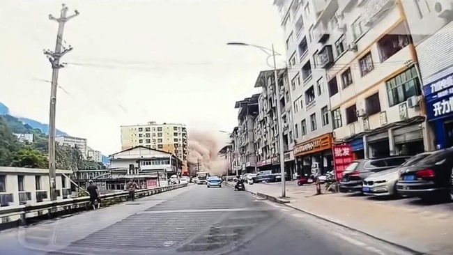 A dashcam video on a screen shows a cloud of dust rising as buildings collapse due to a landslide in Chongqing, China, July 17, 2026, in this screengrab obtained from a social media video. Social Media/via REUTERS  THIS IMAGE HAS BEEN SUPPLIED BY A T