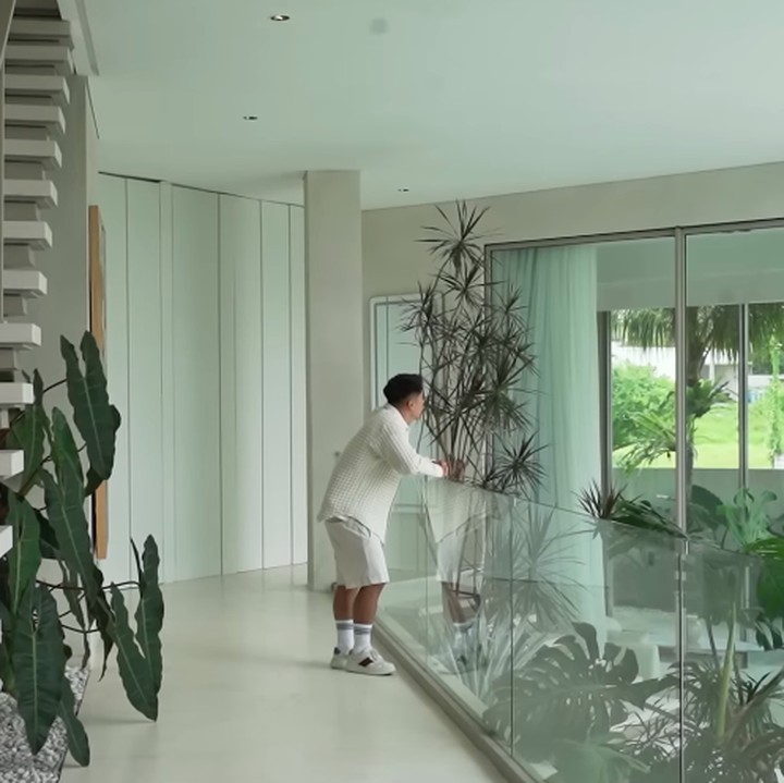 <p>Boy mengawali turnya dengan memperlihatkan <em>main foyer</em> yang menyerupai koridor semi terbuka. Ia sengaja menghadirkan banyak tanaman hijau di sepanjang jalur masuk agar setiap tamu langsung disambut suasana alami. &ldquo;Kita langsung disambut sama alam karena saya mempunyai visi bahwa saya ingin orang-orang datang ke buka pintu itu dan langsung disambut sama banyak tanaman, banyak tanaman hijau,&rdquo; tuturnya.&nbsp;(Foto: YouTube BW.)</p>