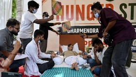 Cockroach Janta Party (CJP) founder Abhijeet Dipke (2R) reacts as doctors check activist Sonam Wangchuks vital signs during his hunger strike in New Delhi on July 15, 2026, demanding the resignation of Indias Education Minister Dharmendra Pradhan ove