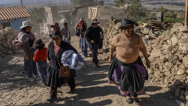 People walk past damaged houses following the earthquake of magnitude 5.6 that struck Central Peru on Saturday, in Pumpunya, Chupaca province, Junin region, Peru, July 19, 2026. REUTERS/Yershon Vilca