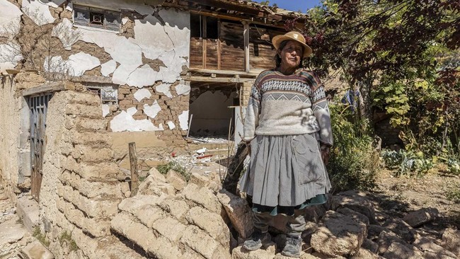 Roxana Torres, 64, poses beside her damaged house following the earthquake of magnitude 5.6 that struck Central Peru on Saturday, in Pumpunya, Chupaca province, Junin region, Peru, July 19, 2026. REUTERS/Yershon Vilca