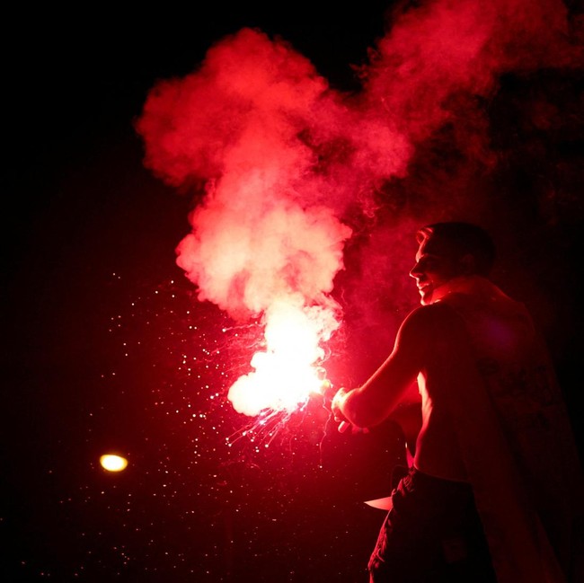 Soccer Football - FIFA World Cup 2026 - Final - Spain v Argentina - Fans gather in Madrid - Madrid, Spain - July 20, 2026 Spain fan lights a flare as they celebrate at Plaza de Cibeles in Madrid after Spain win the FIFA World Cup final against Argent