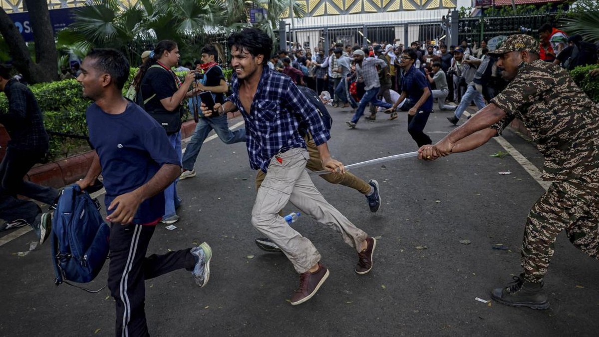 A security force personnel wields his baton against demonstrators at a protest site during a planned march by supporters of India's Cockroach Janta Party towards parliament on the opening day of its monsoon session, demanding the resignation of Educa