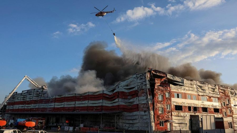 Sebuah helikopter pemadam kebakaran menjatuhkan air ke letak serangan rudal Rusia, di tengah serangan Rusia terhadap Ukraina, di wilayah Kyiv, Ukraina, 19 Juli 2026.
