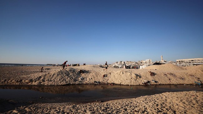 Wastewater flows next to tents sheltering displaced Palestinians, in Gaza City, July 14, 2026. REUTERS/Dawoud Abu Alkas