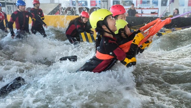 Participants brace for surging water in a flash flood simulator during a typhoon survival training session at the Lvxing Disaster Simulation Training Center in Hangzhou, Zhejiang province, China July 15, 2026. REUTERS/Go Nakamura