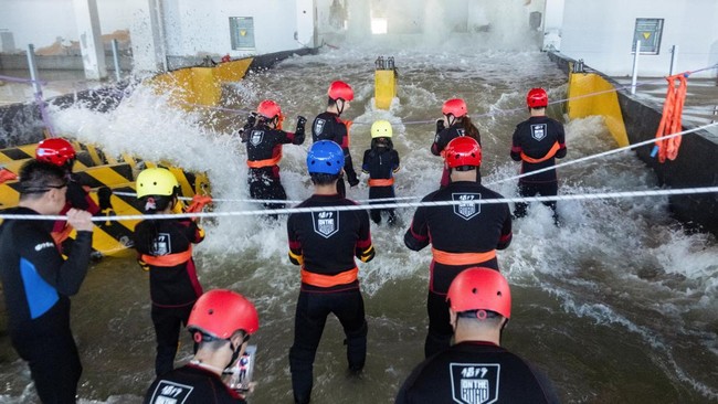 Participants brace for surging water in a flash flood simulator during a typhoon survival training session at the Lvxing Disaster Simulation Training Center in Hangzhou, Zhejiang province, China July 15, 2026. REUTERS/Go Nakamura