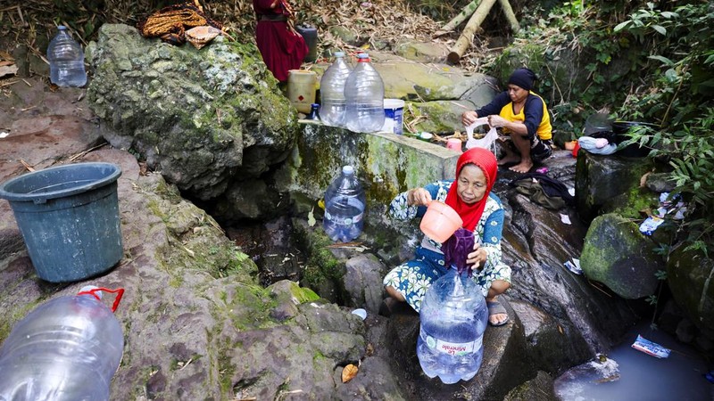 Penduduk desa mengumpulkan air mata air di daerah yang dilanda kekeringan selama musim kemarau, di tengah perkiraan bahwa El Niño dapat menyebabkan kondisi yang lebih kering dari biasanya, di desa Gunung Batur, Cilegon. (REUTERS/Ajeng Dinar Ulfiana)