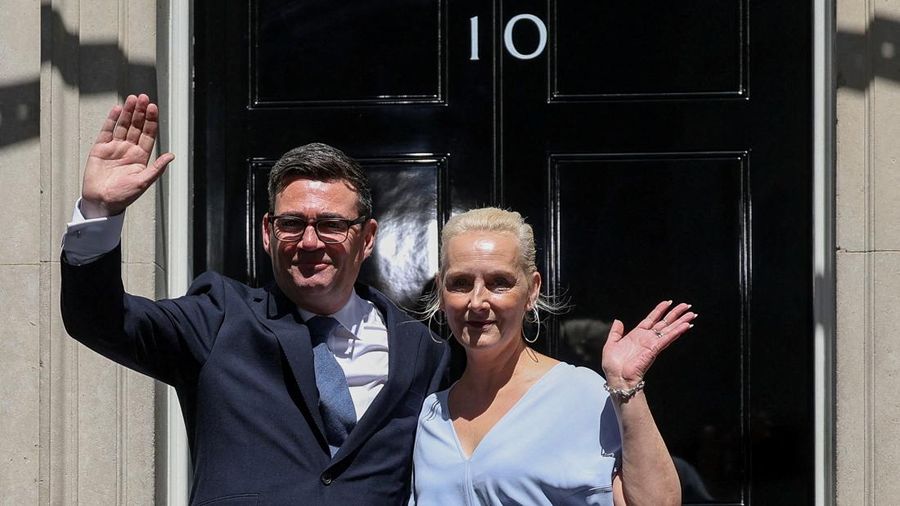 Perdana Menteri Inggris nan baru dilantik, Andy Burnham, melambaikan tangan di luar 10 Downing Street berbareng istrinya, Marie-France van Heel, setelah resmi menjabat, di London, Inggris, 20 Juli 2026.