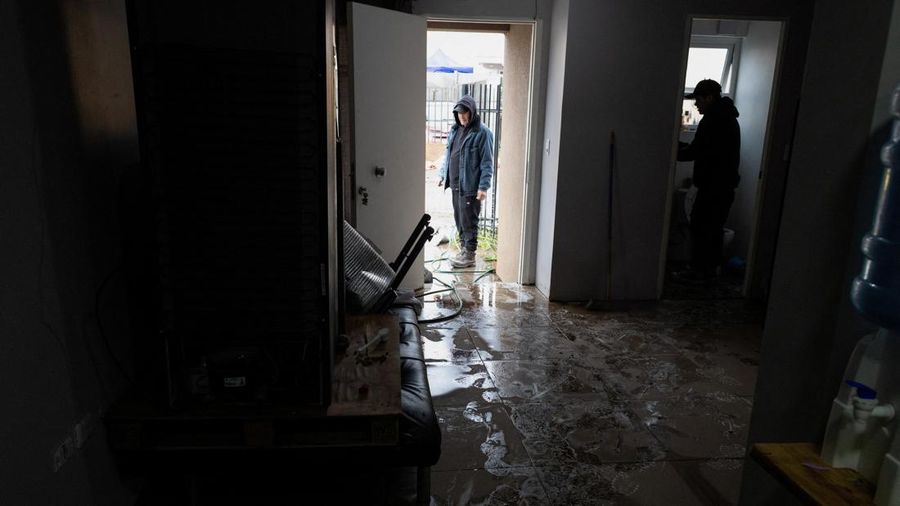 Santiago Ramirez dan saudaranya membersihkan rumah mereka setelah hujan deras akibat front cuaca nan menyebabkan banjir dan mendorong pihak berkuasa Chili untuk menyatakan keadaan darurat preventif pada awal pekan ini, di Talagante, Chili, 18 Juli