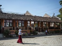 Siswa berjalan membawa paket Makan Bergizi Gratis (MBG) dekat ruang kelas yang atapnya ambruk di SD Negeri Tanggirejo, Tegowanu, Grobogan, Jawa Tengah, Selasa (21/7/2026). Menurut pihak sekolah menyebutkan bahwa atap bangunan ruang kelas pertama kali
