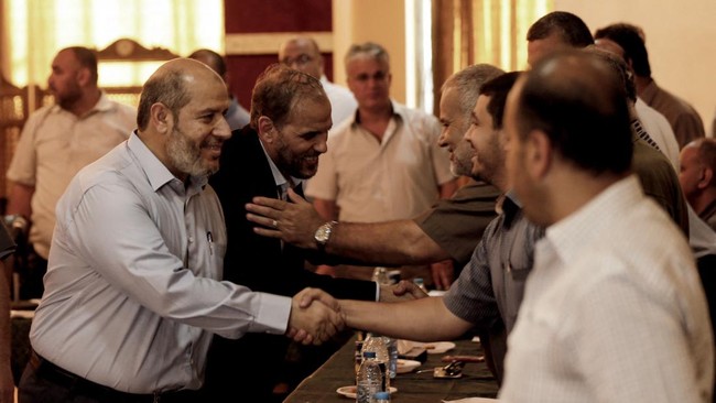 Hamas officials Husam Badran (2nd-L) and Khalil al-Hayya (L) arrive for a meeting with Palestinian factions in Gaza City on August 5, 2018. (Photo by MAHMUD HAMS / AFP)