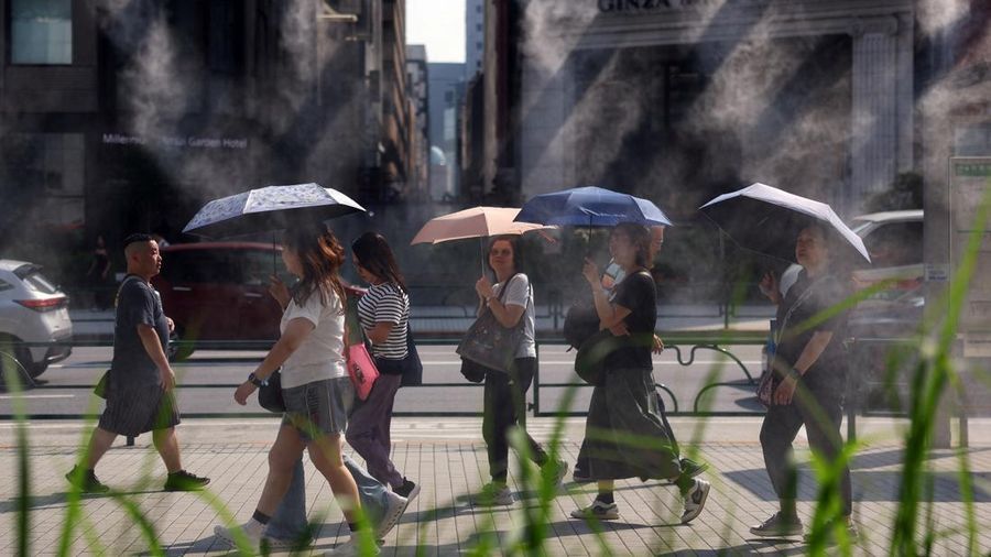 Orang-orang nan membawa payung melangkah di dekat kabut nan menyejukkan saat pemerintah Jepang mengeluarkan peringatan serangan panas di Tokyo dan prefektur lainnya lantaran gelombang panas, di Tokyo, Jepang, 22 Juli 2026.