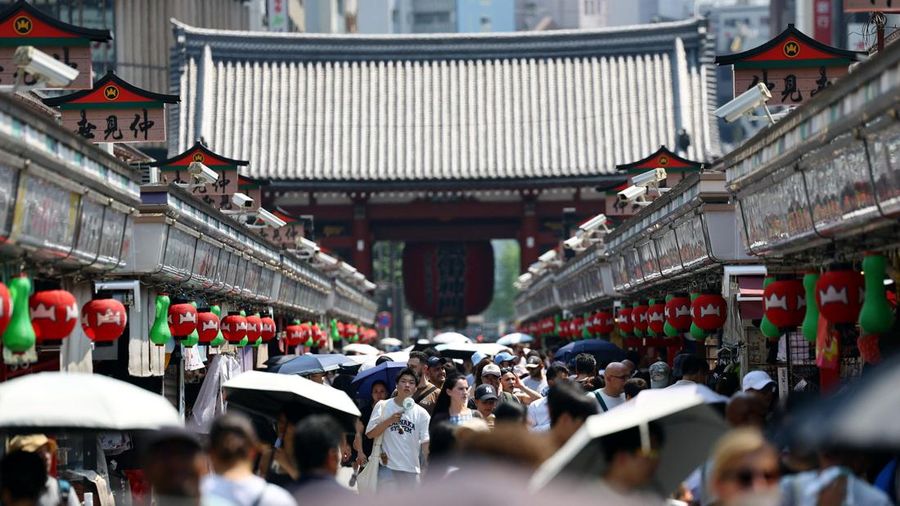 Para visitor nan membawa payung melangkah di sepanjang Jalan Nakamise di distrik Asakusa, sebuah lokasi wisata populer, saat pemerintah Jepang mengeluarkan peringatan serangan panas di Tokyo dan prefektur lainnya lantaran gelombang panas, di Tokyo, Jepang, 22 Juli 2026.