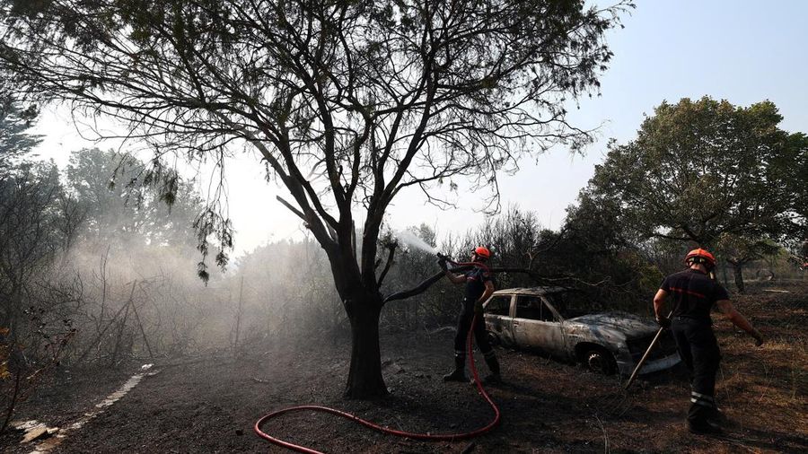 Petugas pemadam kebakaran Prancis menyemprotkan air selama operasi pembersihan di dekat sebuah rumah dan mobil nan terbakar di wilayah nan terkena akibat kebakaran rimba di Cotignac, departemen Var, saat kondisi kekeringan memburuk setelah gelombang panas dan kekurangan air di sebagian besar wilayah Prancis, 22 Juli 2026.