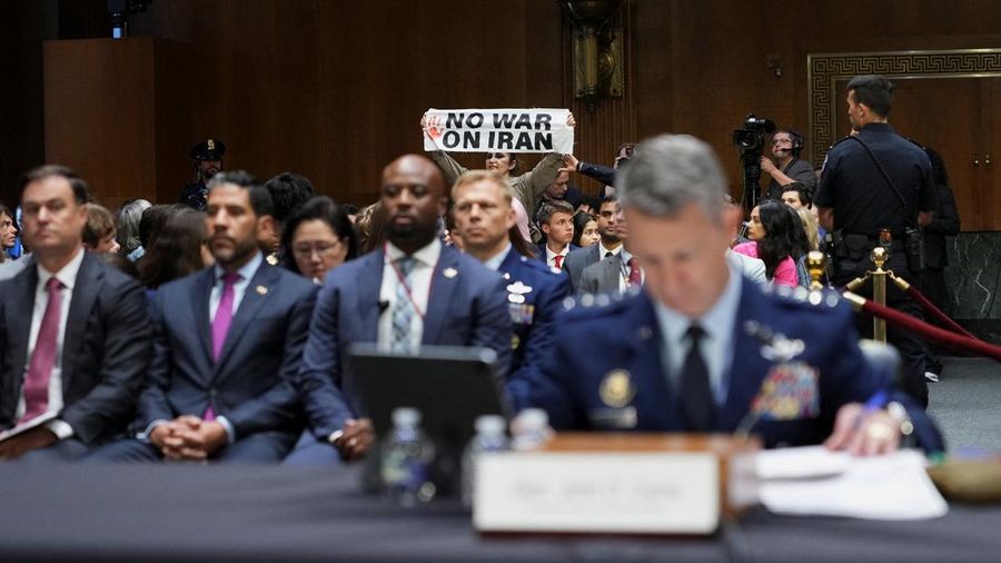 Seorang demonstran berdiri dan membentangkan poster menolak perang terhadap Iran saat sidang Komite Alokasi Anggaran Senat mengenai permintaan pendanaan tambahan Presiden AS Donald Trump untuk Departemen Pertahanan, di Washington, D.C., AS, Selasa (21/7/2026),