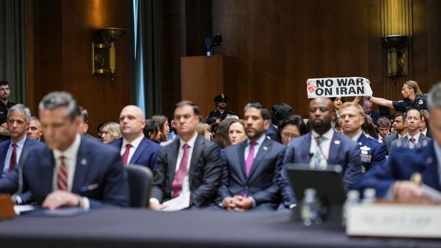 Seorang demonstran berdiri dan membentangkan poster menolak perang terhadap Iran saat sidang Komite Alokasi Anggaran Senat mengenai permintaan pendanaan tambahan Presiden AS Donald Trump untuk Departemen Pertahanan, di Washington, D.C., AS, Selasa (21/7/2026), (REUTERS/Eric Lee)